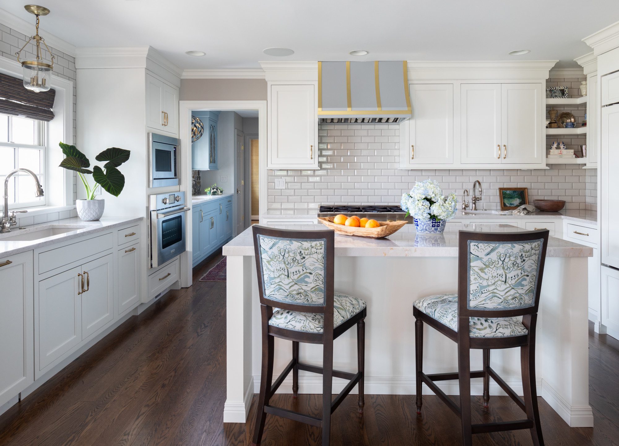 View of a clean and fresh kitchen with a blue, white and gold color scheme.