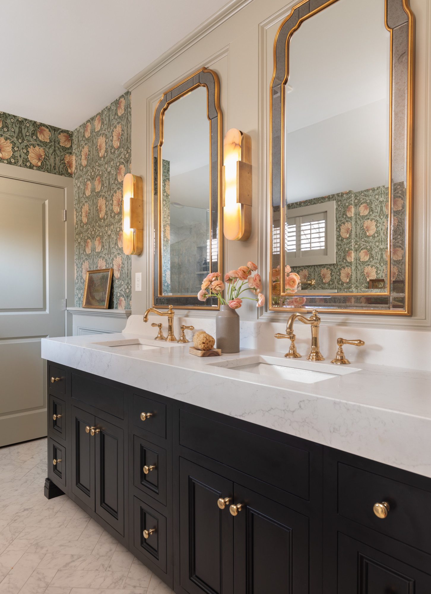 luxurious double vanity with gold accents and dark cabinetry, surrounded with beautiful floral wallpaper