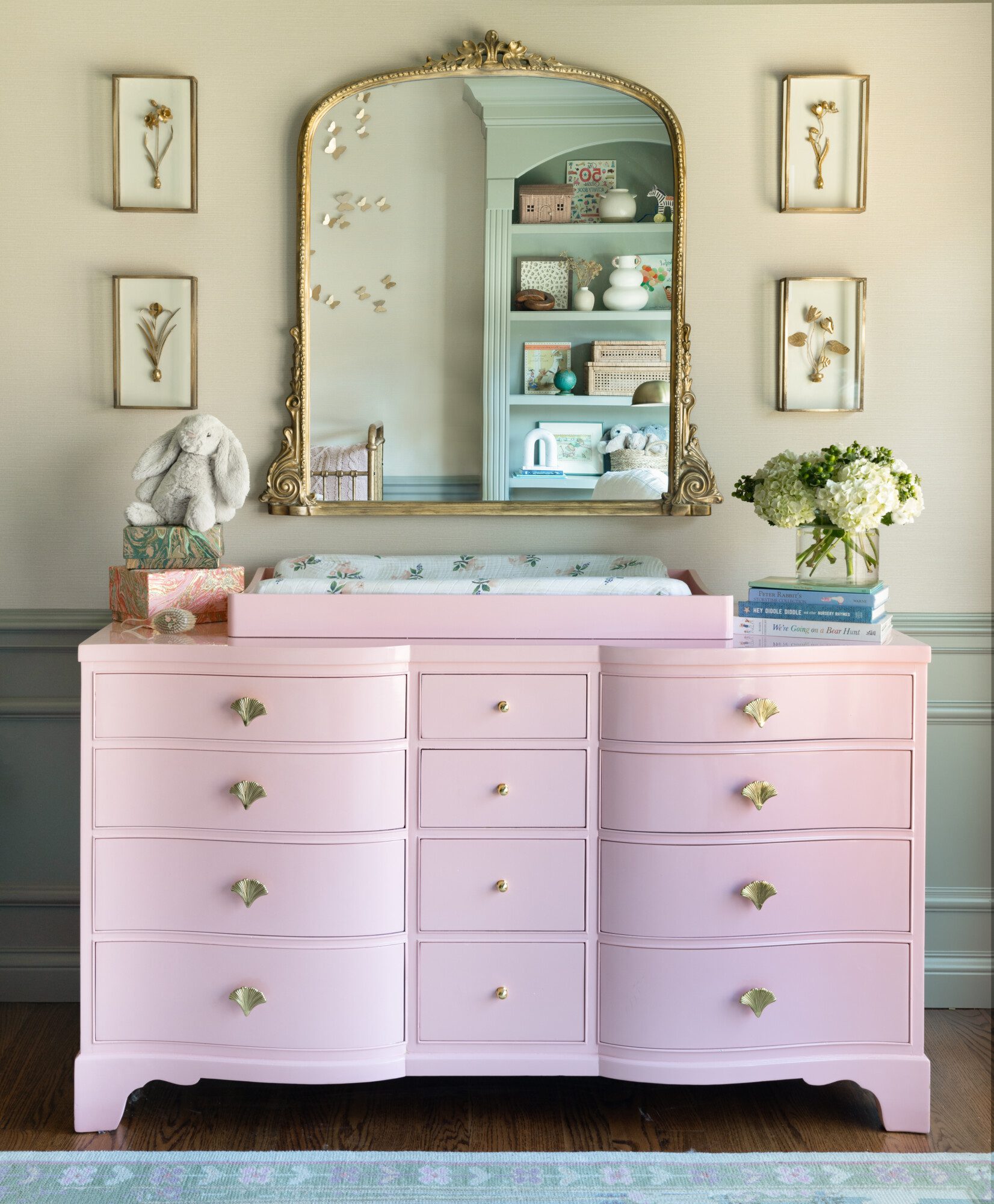 A sweet pink dresser with a gold antiqued mirror