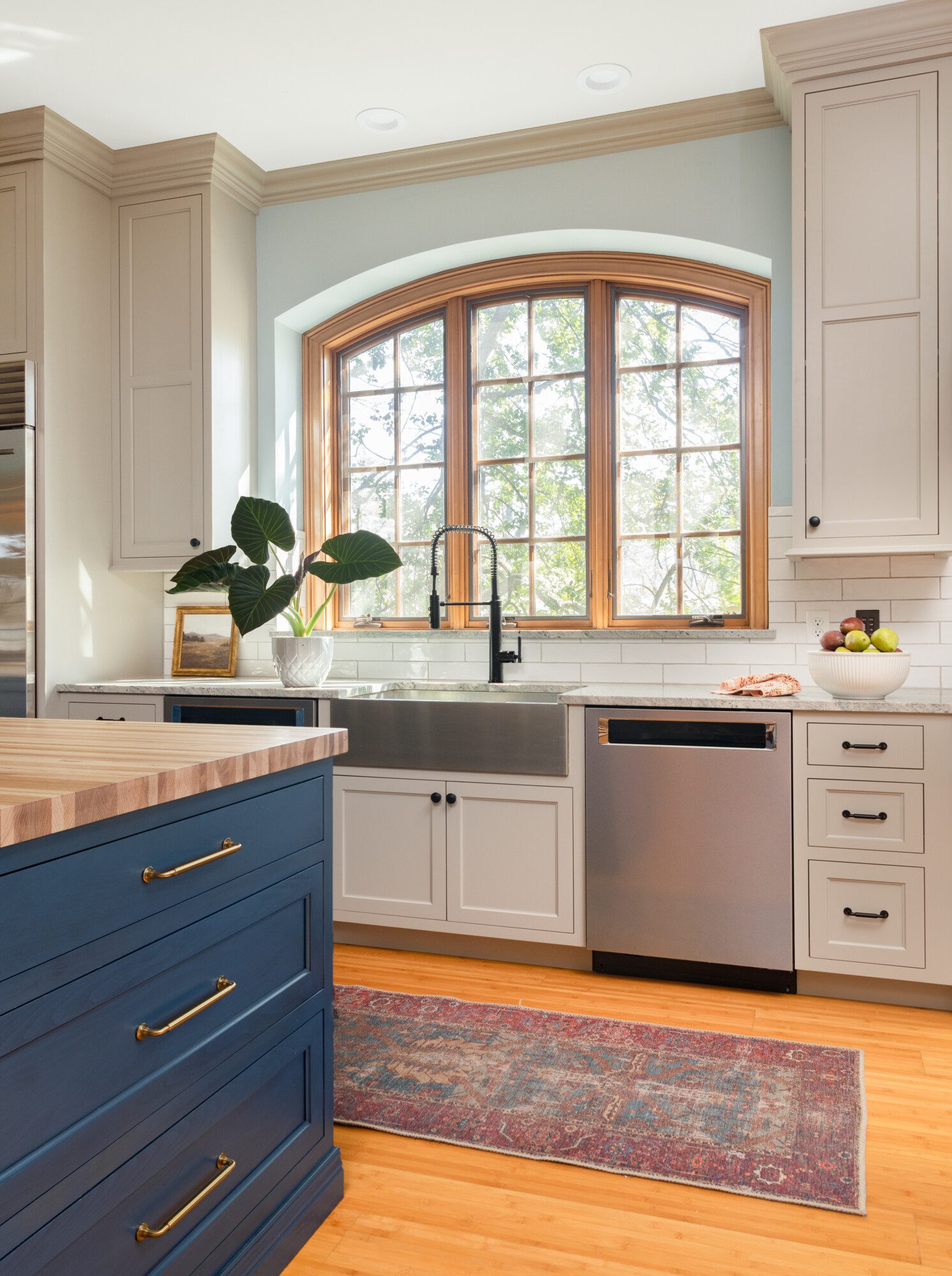 a large window lets in abundant sunshine into a beautiful kitchen