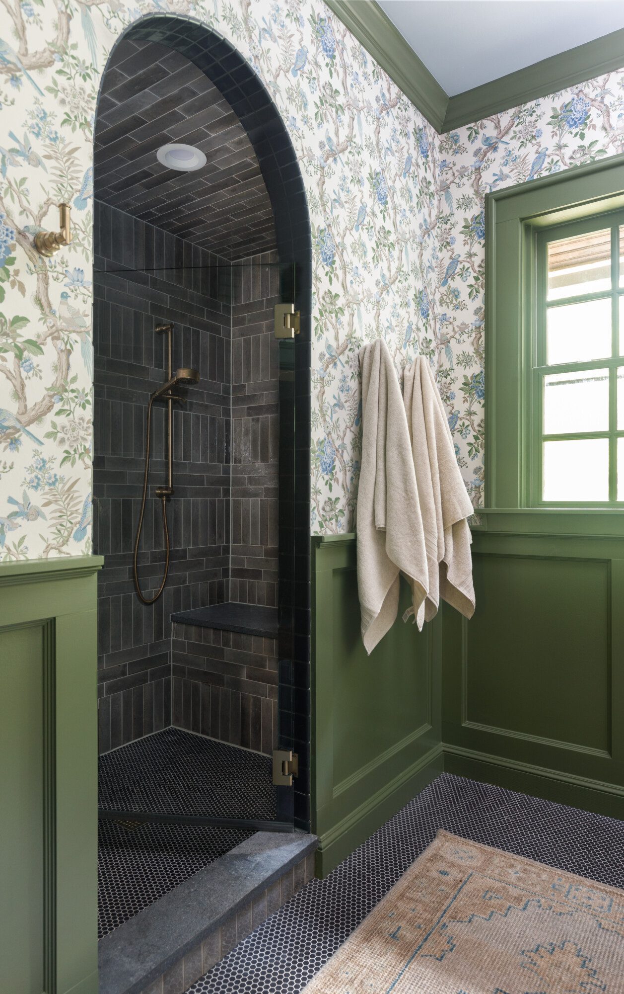 Bathroom with green cabinets, flower wallpaper, and checkered floor