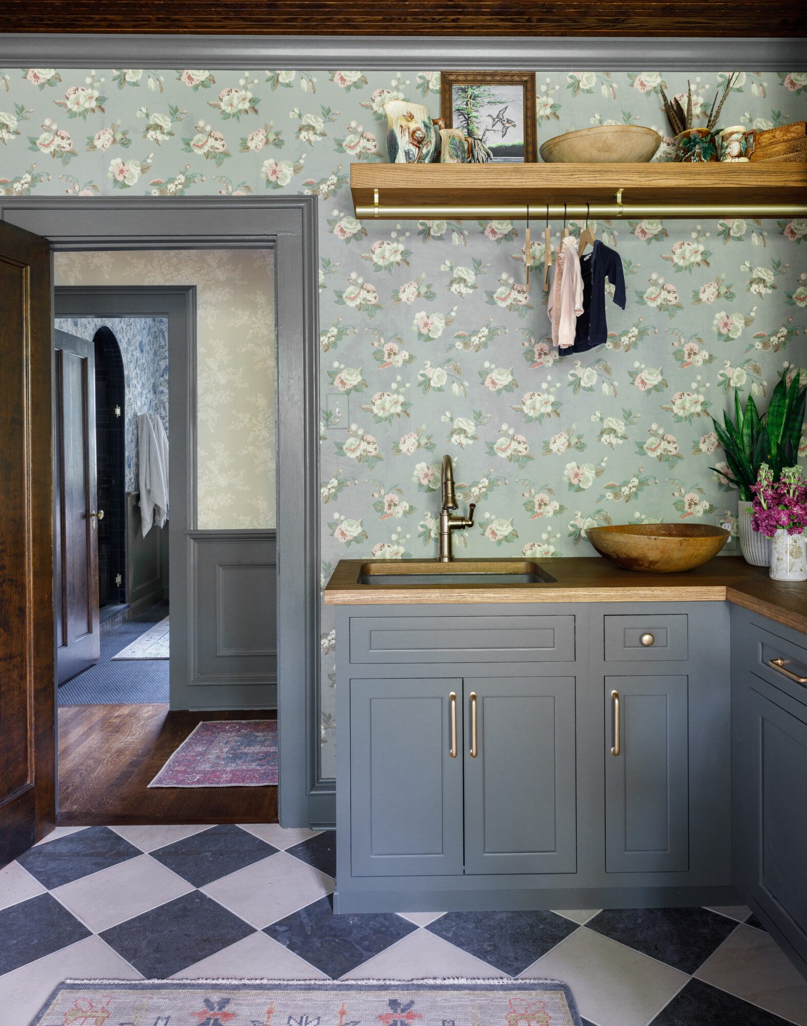 Laundry room with green cabinets, flower wallpaper and checkered floor