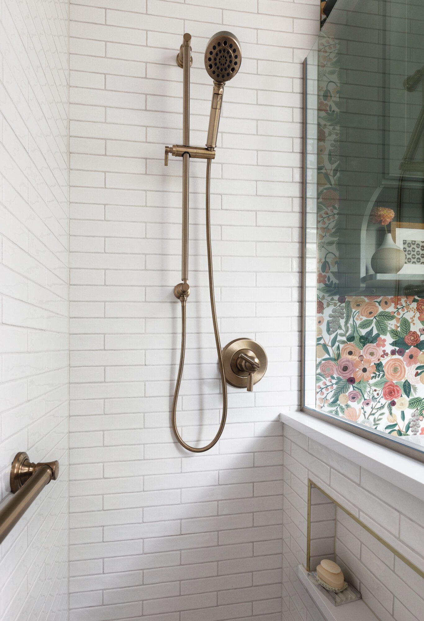 White tile shower with gold hardwear
