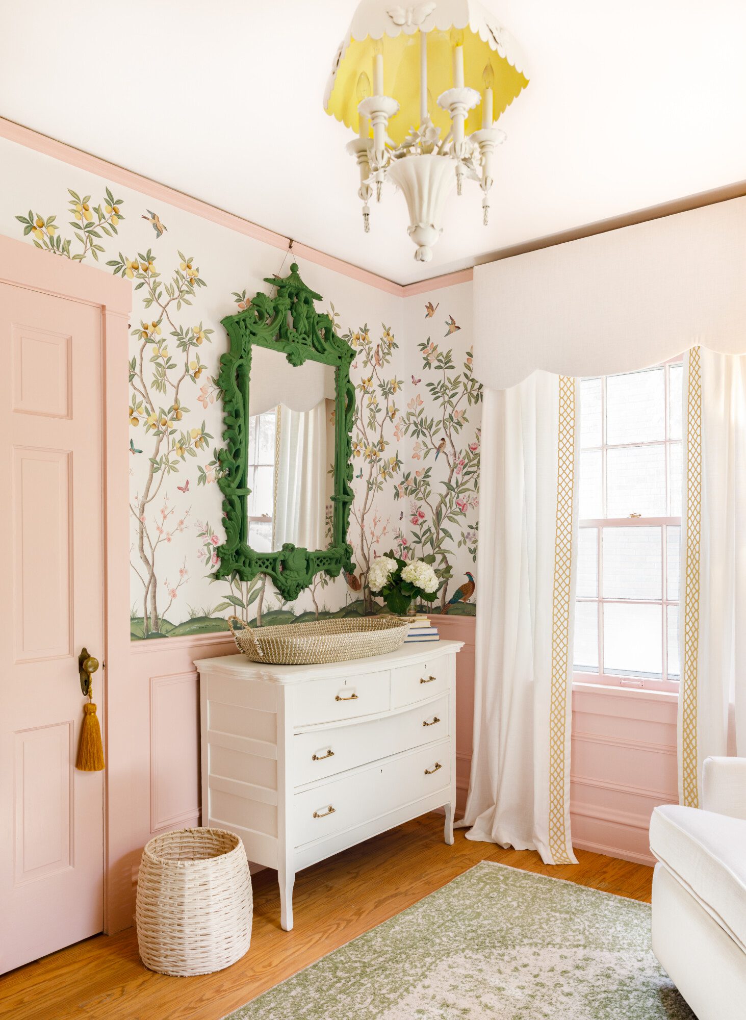 lovely pink and green baby room with nature-inspired wallpaper