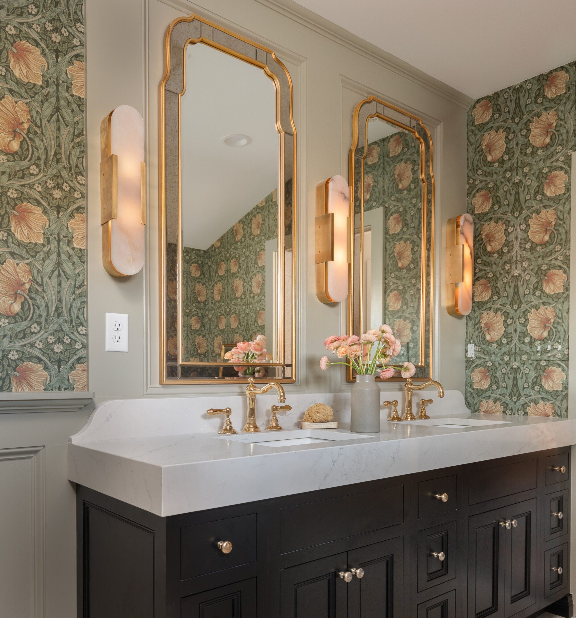 Bathroom with flower pattern wallpaper and marble countertops and gold accents