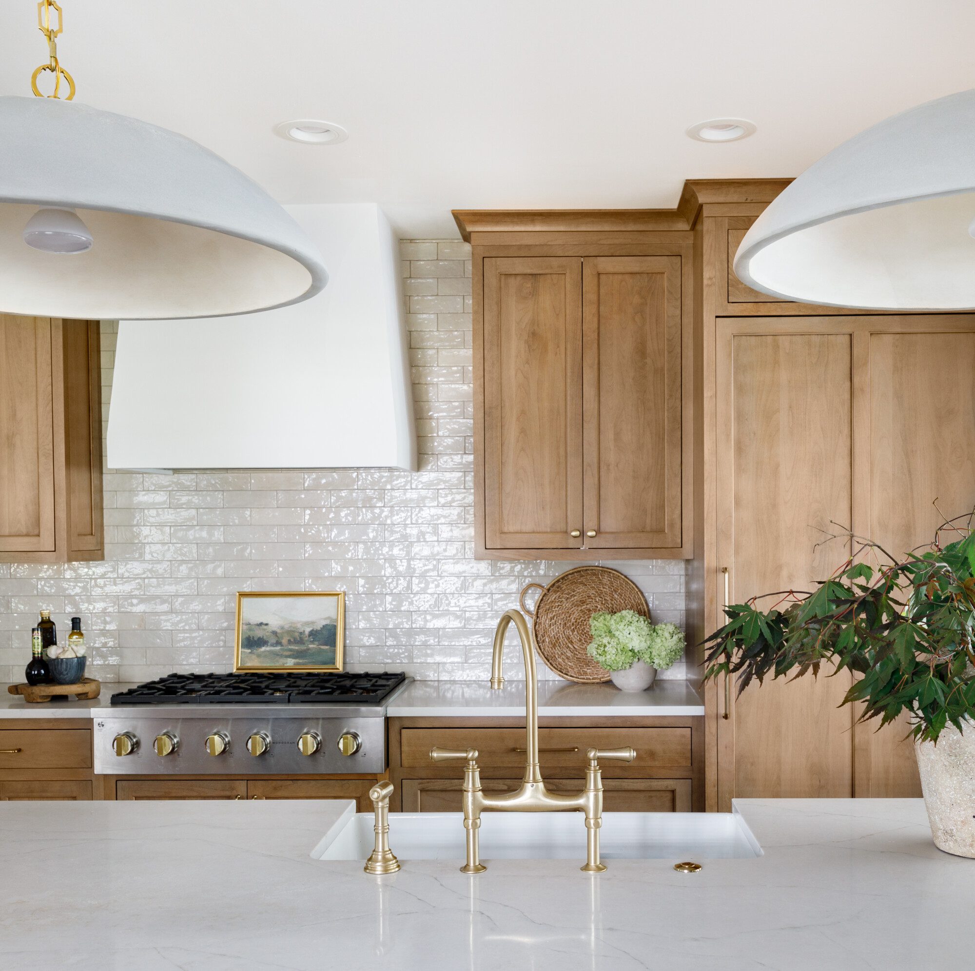 Beautiful kitchen with light stained wood and white and gold accents