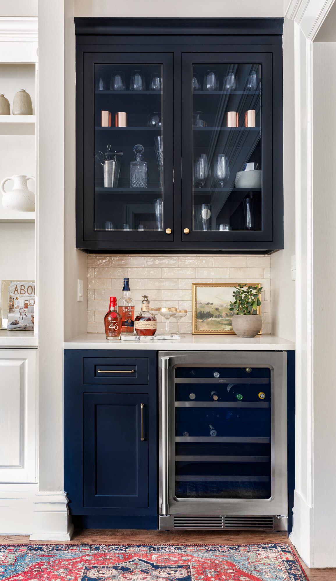 Bright bar area with white tile backsplash and navy blue cabinets