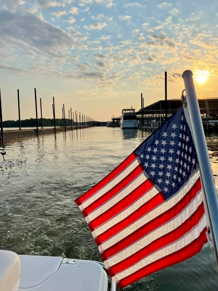 Sun setting on the river with a flag in the foreground