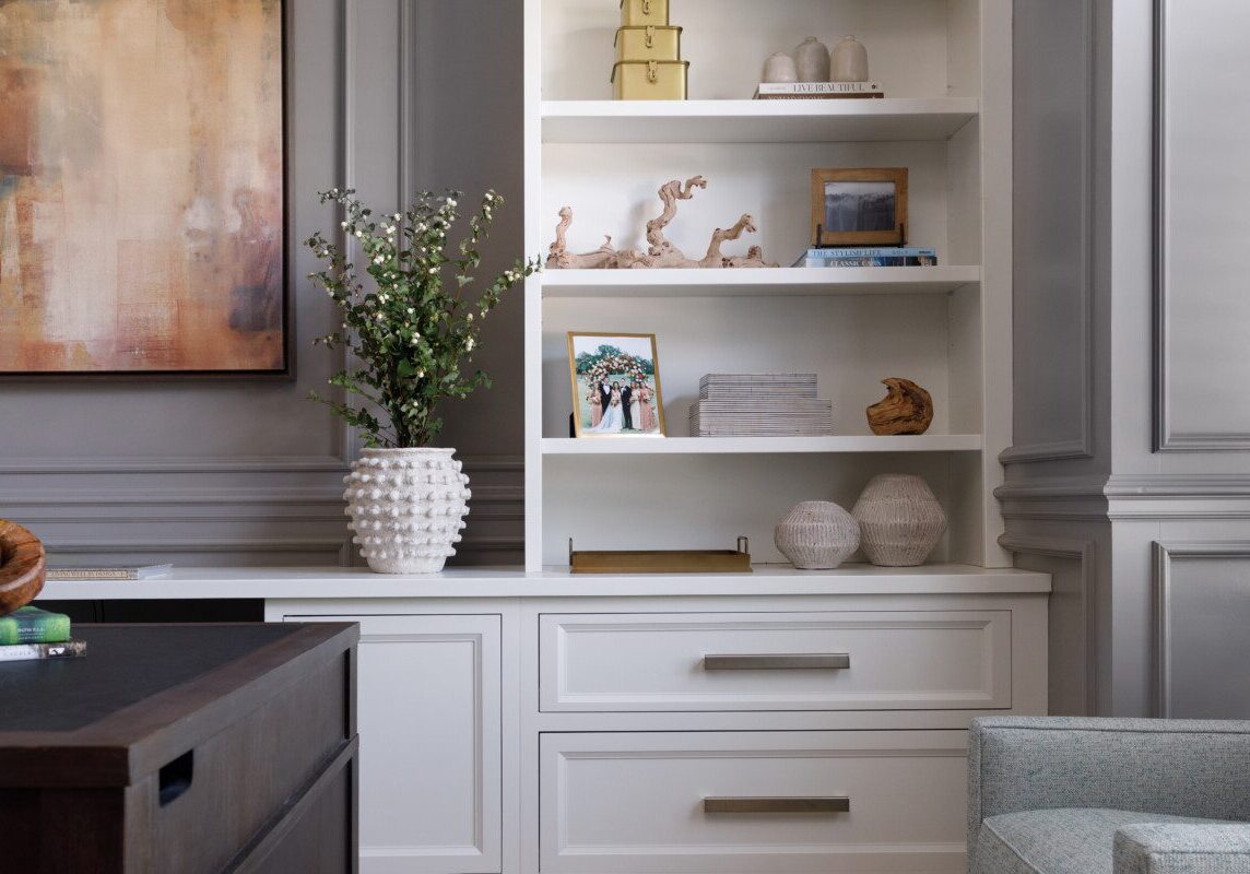White bookshelf against grey walls with wall molding