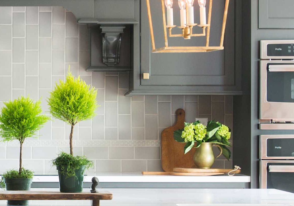 This space was transformed from dark & gloomy to now happily welcoming everyone. Charcoal colored cabinets and the light aluminum tile backsplash create an elegant pairing.