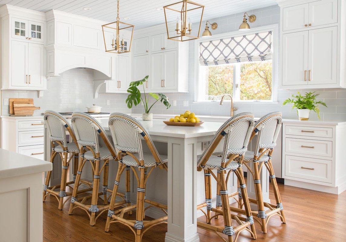 a spacious bright white kitchen with gold fixtures and blue accents