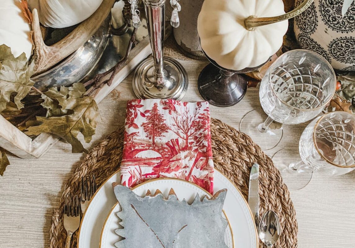 IMG_7692 A large spread of thanksgiving decor with wicker placemats, white pumpkins, and other decorative items.