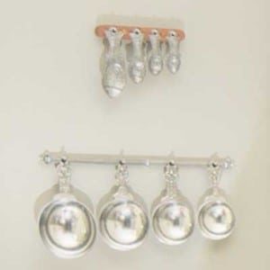 close up of silver measuring spoons hanging on wall
