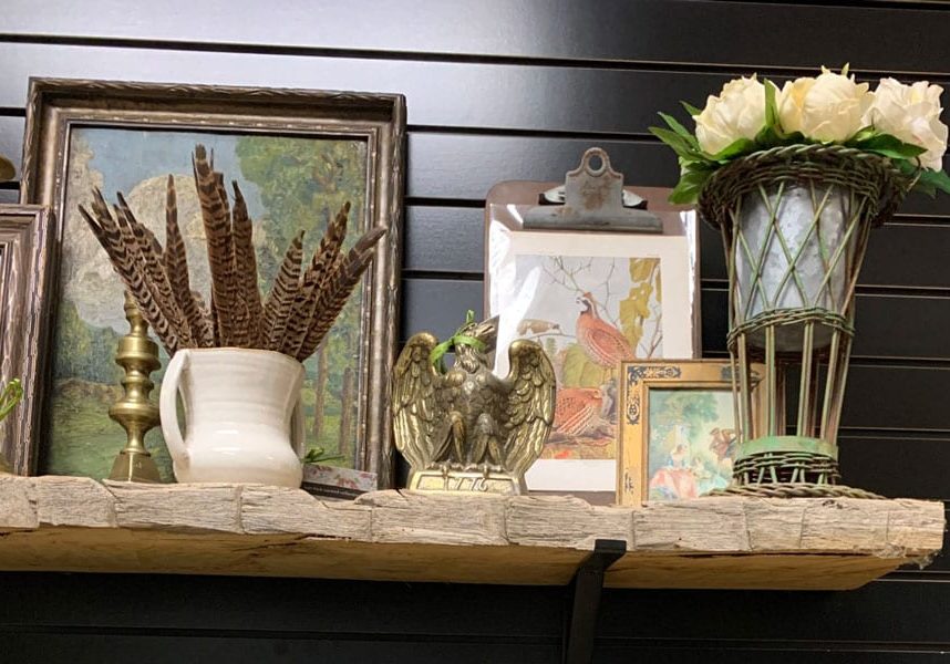a rustic wooden mantel with vintage and brass decor